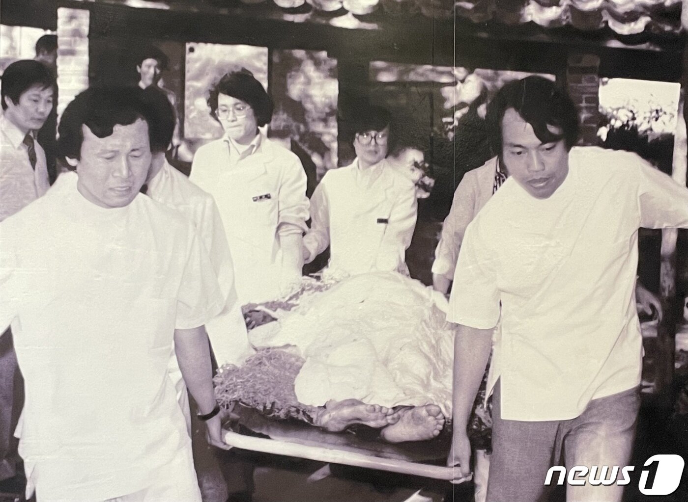 본문 이미지 - 5·18 당시 시민들이 부상자를 후송하는 모습. 병원에서는 환자를 이송하는 시민들에게 하얀 가운을 제공했다. ⓒ 뉴스1 /NEWS1DB