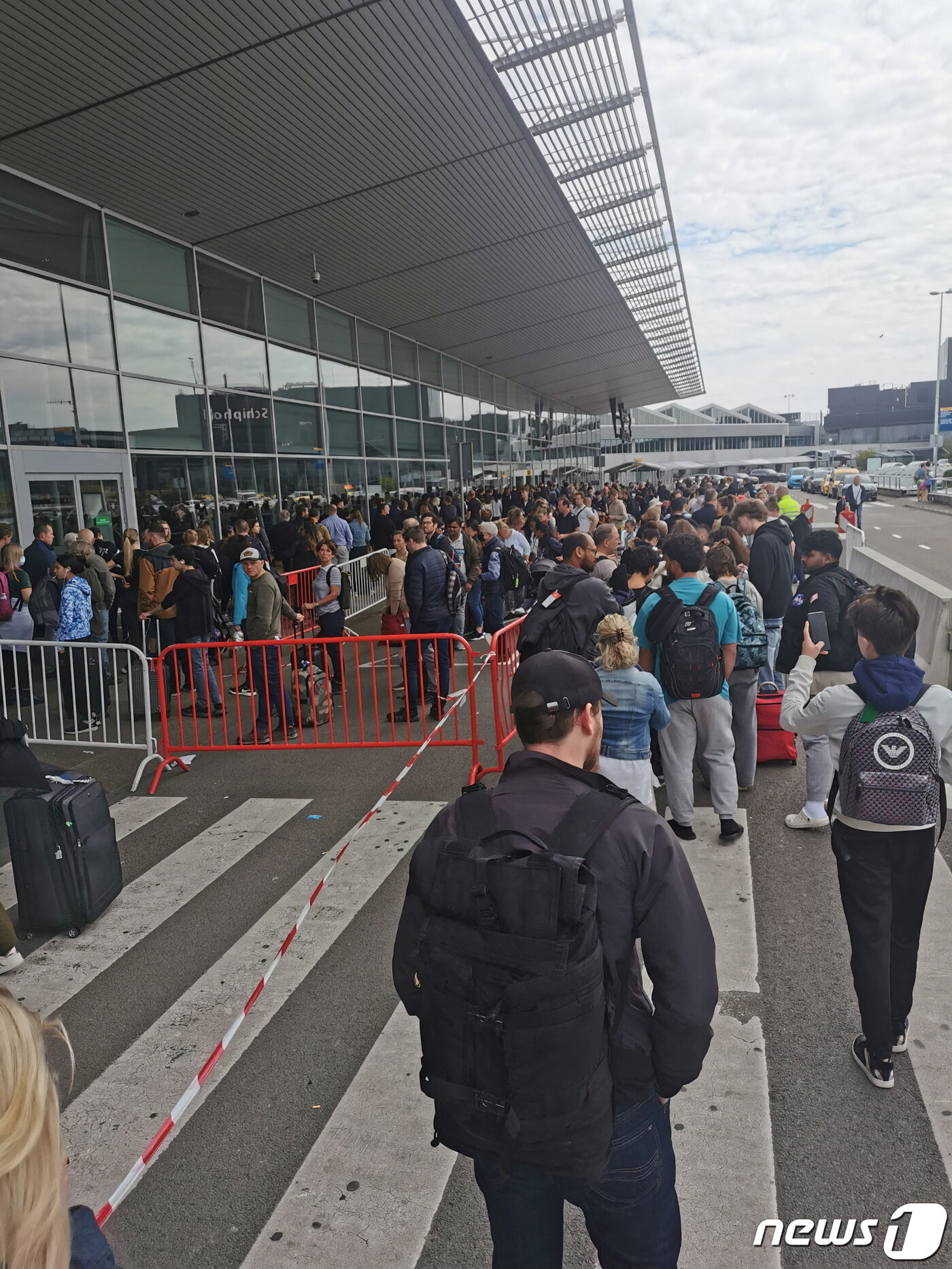본문 이미지 - 4일(현지시간) 네덜란드 암스테르담 스키폴 공항에서 공항 보안 요원 부족으로 여행객들이 공항에 들어가지 못 한 채 밖까지 줄을 서 있다. ⓒ 로이터=뉴스1 ⓒ News1 김예슬 기자