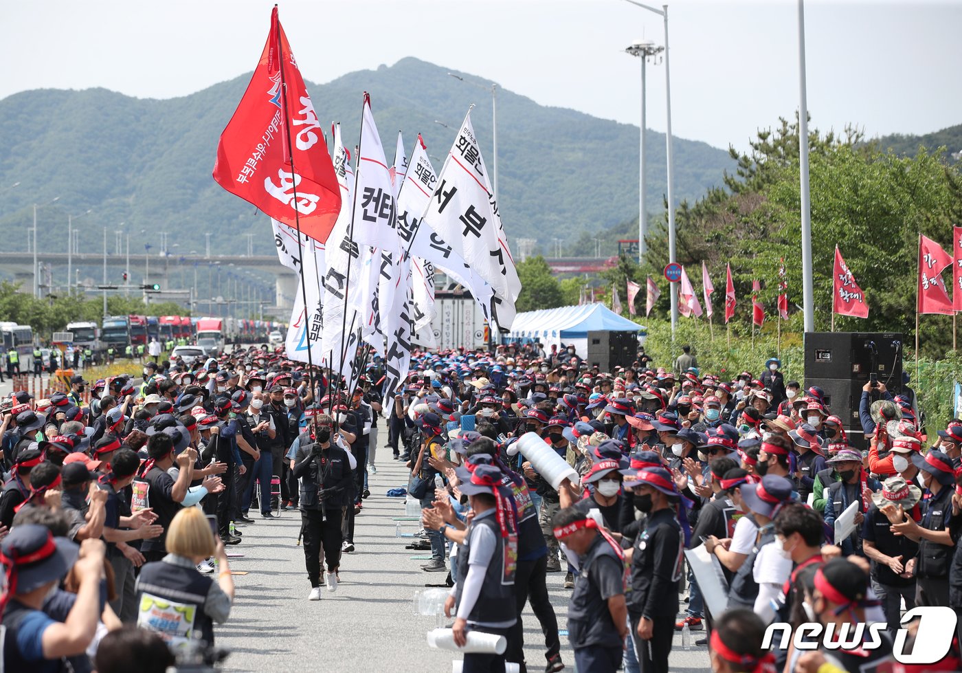 화물연대가 무기한 총파업에 돌입한 지난 6월7일 부산시 강서구 부산신항앞 삼거리에서 열린 &#39;화물연대 총파업 출정식&#39;에서 화물차량 노동자들 총파업 깃발을 가지고 나오고 있다.2022.6.7/뉴스1 ⓒ News1 김영훈 기자