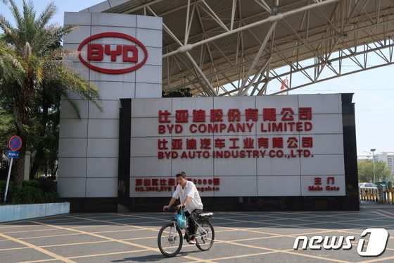 한 남성이 선전에 위치한 중국 최대 전기차 업체 BYD 공장 정문 앞을 지나가고 있다. © 로이터=뉴스1 © News1 박형기 기자