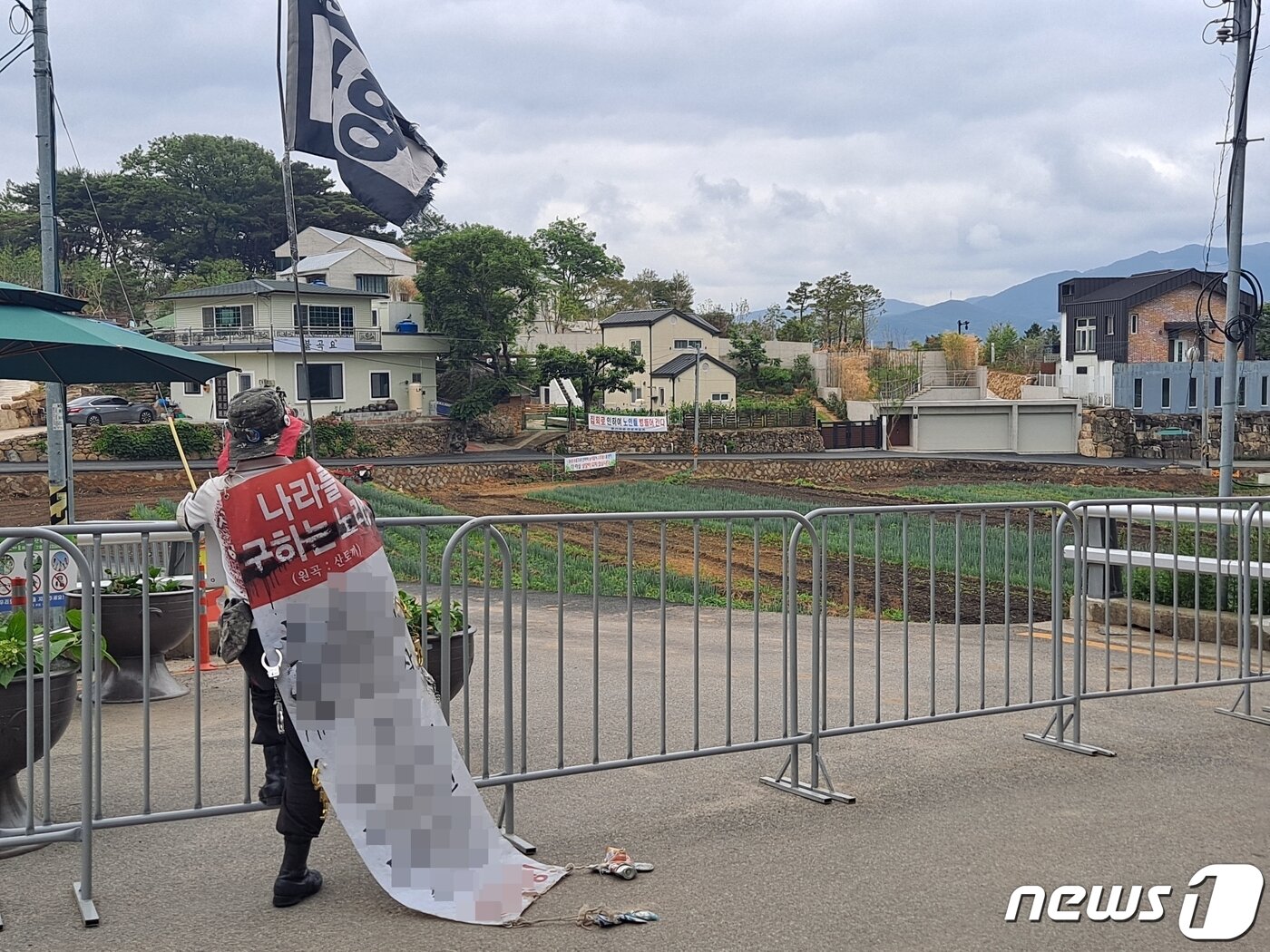본문 이미지 - 8일 오후 경남 양산시 하북면 평산마을 문재인 전 대통령 사저 앞에서 한 보수단체 회원이 몸에 현수막과 깡통을 매단 채 시위를 하고 있다. 2020.06.08 ⓒ 뉴스1 김명규 기자