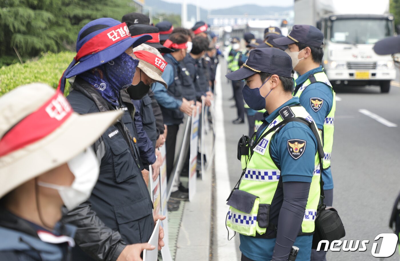 본문 이미지 - 화물연대 총파업 이틀째인 8일 울산시 북구 현대자동차 명촌정문 앞에서 화물연대 울산본부 소속 조합원들이 경찰과 대치하고 있다. 2022.6.8/뉴스1 ⓒ News1 조민주 기자