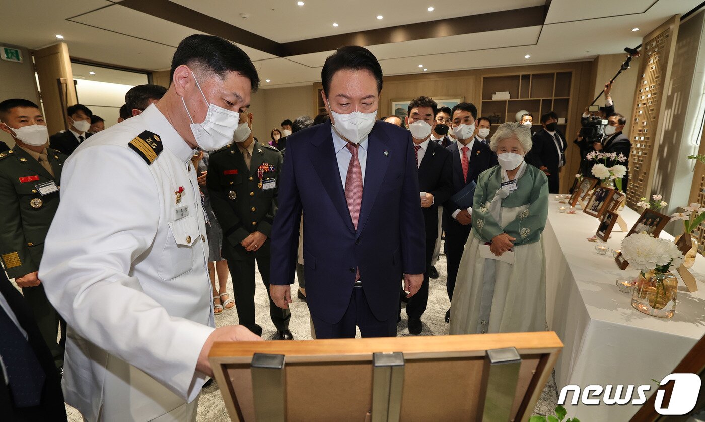본문 이미지 - 윤석열 대통령이 작년 6월9일 서울 용산 대통령실 청사에서 열린 '호국영웅 초청 소통식탁' 행사에 참석, 제2연평해전에 참전한 이희완 국가보훈부 차관 내정자(당시 해군 중령)으로부터 사진설명을 듣고 있다. (대통령실사진기자단) 2022.6.9/뉴스1 ⓒ News1 안은나 기자