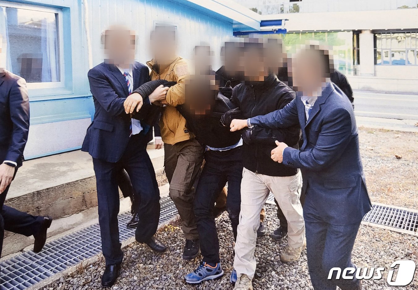 본문 이미지 - 통일부가 공개한 지난 2019년 11월 북한 선원 2명을 판문점을 통해 북송하는 사진. 국민의힘 의원단은 14일(현지시간) 사진에 나온 북한 어민이 1997년생으로 함경북도 청진 출신인 우범선씨라고 신원을 공개했다.  (통일부 제공) 2022.7.12/뉴스1