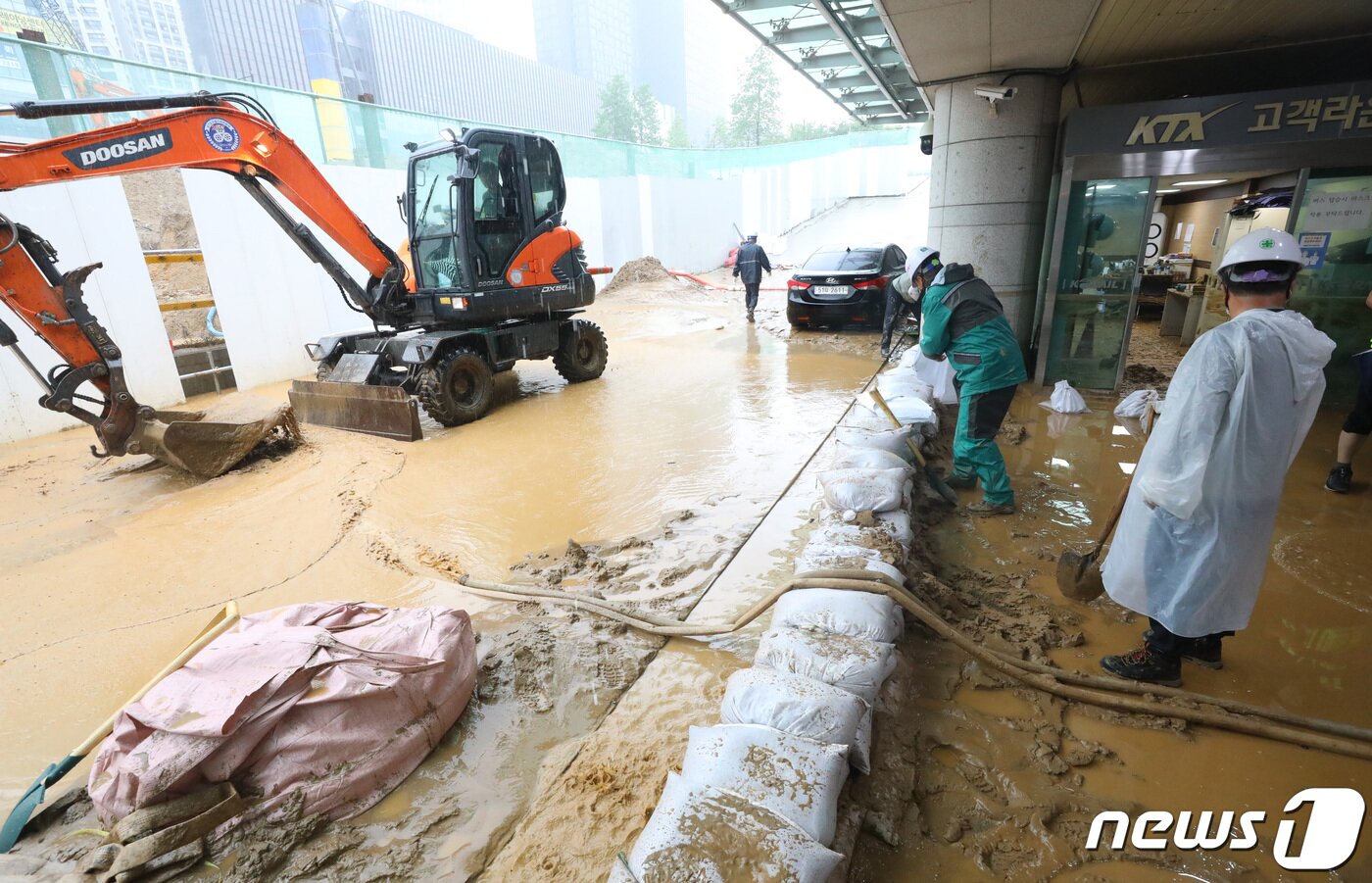 본문 이미지 - 수도권 지역에 호우주의보가 내려진 13일 오후 경기 광명시 일직동 경부선(KTX) 광명역에 인근 신안산선 공사현장의 토사와 흙탕물이 지하 승강장으로 유입돼 현장 관계자들이 토사를 치우고 있다. 2022.7.13/뉴스1 ⓒ News1 김영운 기자