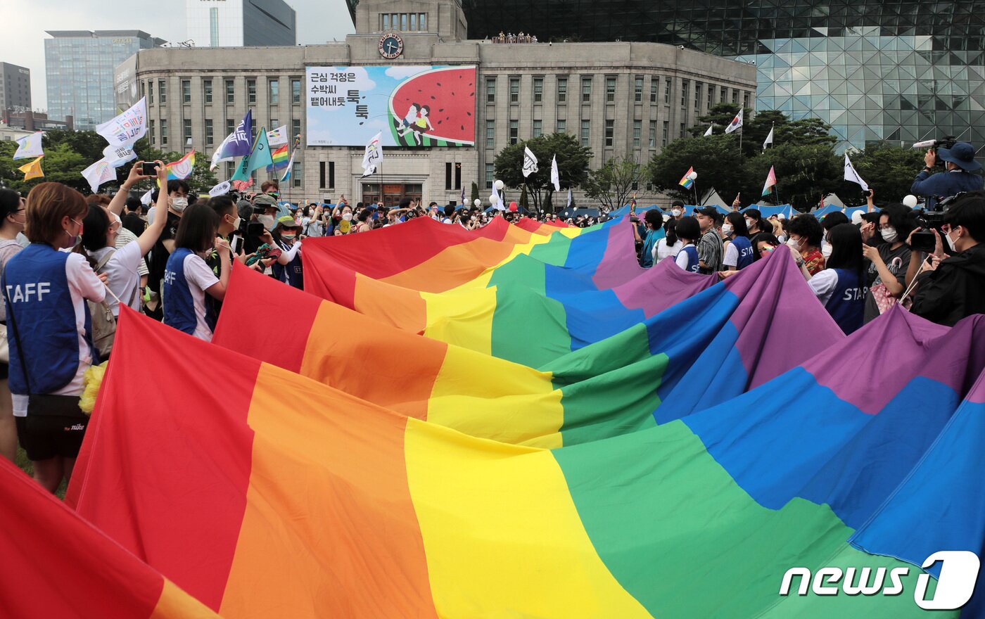 본문 이미지 - 16일 서울광장에서 열린 서울퀴어문화축제를 찾은 시민들이 무지개 깃발이 펼쳐지자 환호하고 있다. 2022.7.16/뉴스1 ⓒ News1 조태형 기자