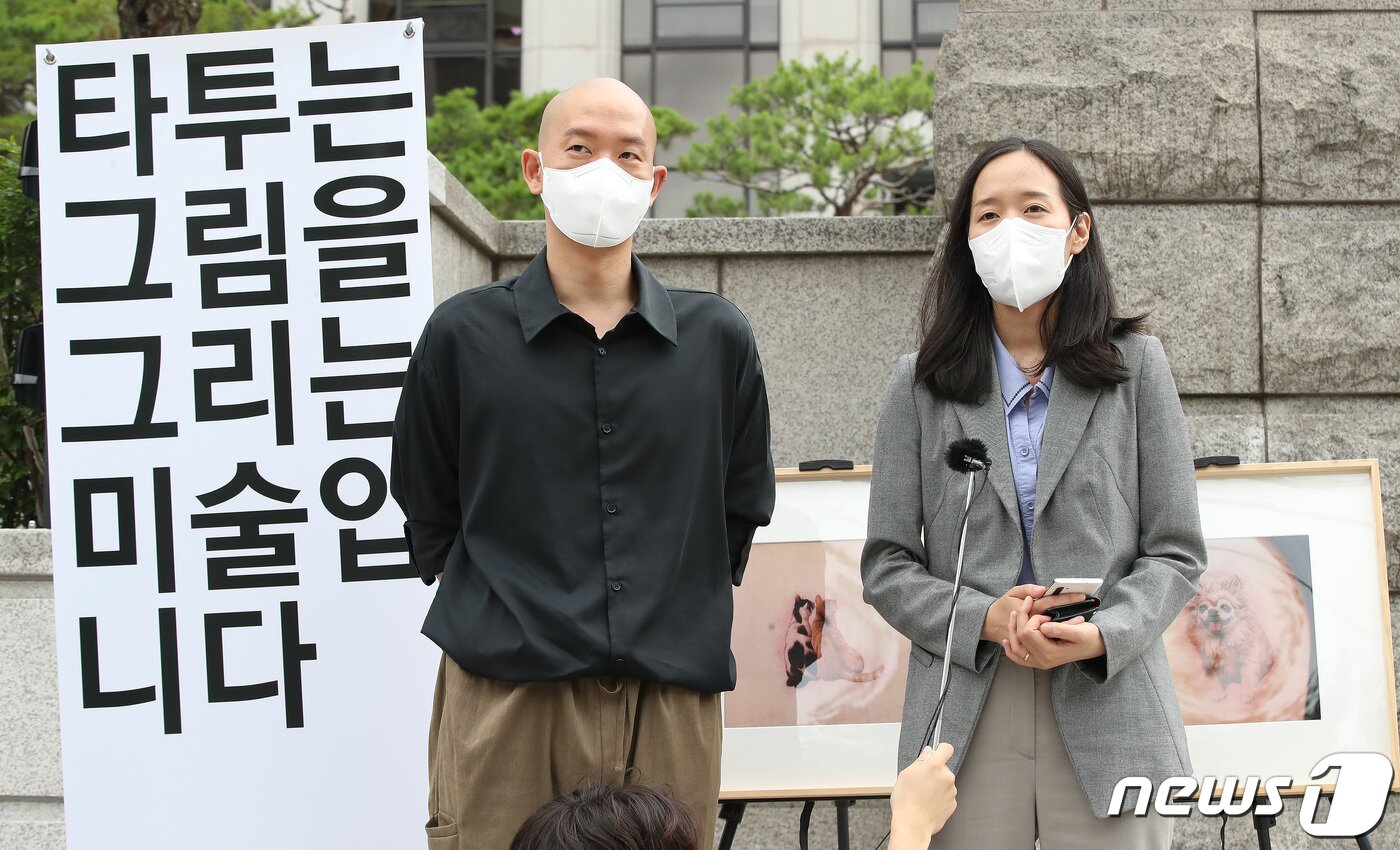 본문 이미지 - 김도윤 타투유니온 지회장과 곽예람 법무법인 오월 변호사가 21일 서울 헌법재판소 앞에서 유명 연예인 타투 관련 사건 재판 중 신청한 헌법소원에 대한 선고(합헌) 이후 기자회견을 하고 있다. 2022.7.21/뉴스1 ⓒ News1 임세영 기자
