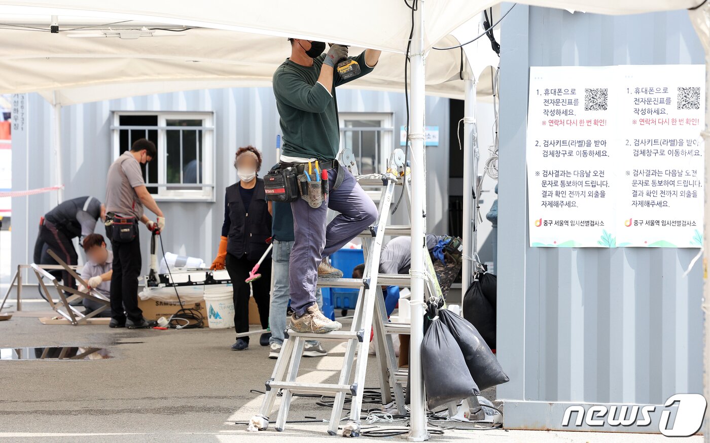 본문 이미지 - 22일 오전 서울역광장에서 서울시 관계자들이 코로나19 임시선별진료소를 재설치하고 있다. 코로나19 재유행 확산 속도가 빨라짐에 따라 오늘부터 도봉구청, 노원구민의전당, 낙성대공원, 고속터미널역 등에 임시선별검사소가 설치되며, 나머지 각 자치구도 다음 주 중 설치 일정을 확정할 예정이라고 서울시는 밝혔다. 2022.7.22/뉴스1 ⓒ News1 김진환 기자