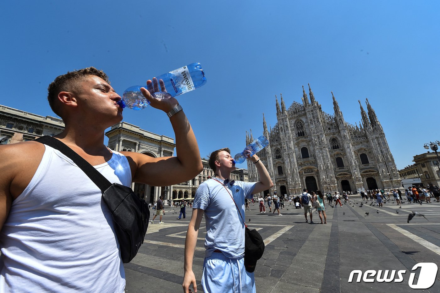본문 이미지 - 이탈리아 밀라노 두오모 성당 앞에서 찌는 듯한 폭염 속 물을 마시는 행인의 모습. 2022. 7. 21. ⓒ 로이터=뉴스1 ⓒ News1 최서윤 기자
