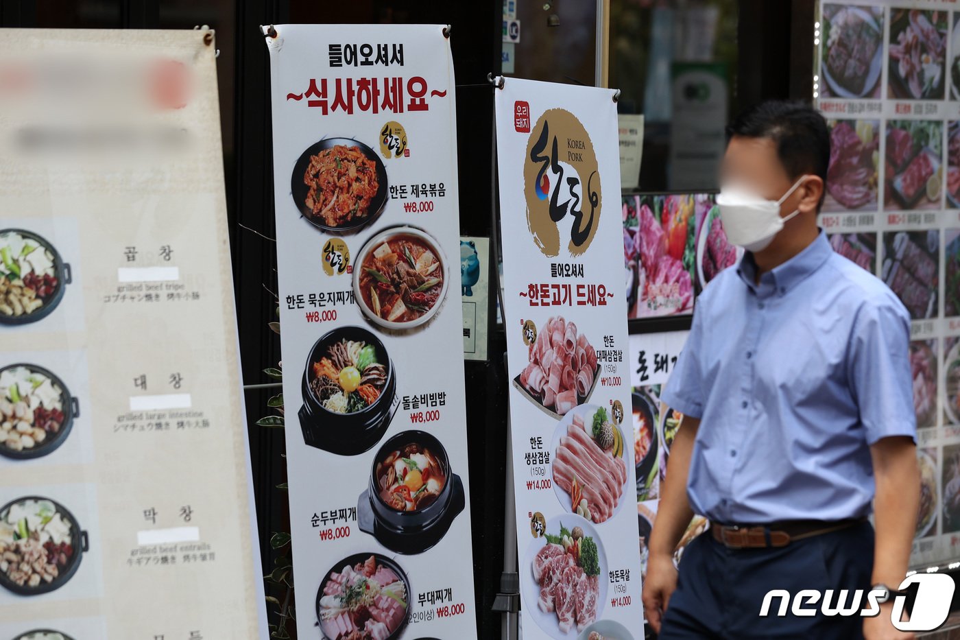  서울 시내 한 거리에서 시민들이 마스크를 착용한 채 식당 메뉴 알림판 앞을 지나고 있다. 2022.7.25/뉴스1 ⓒ News1 조태형 기자