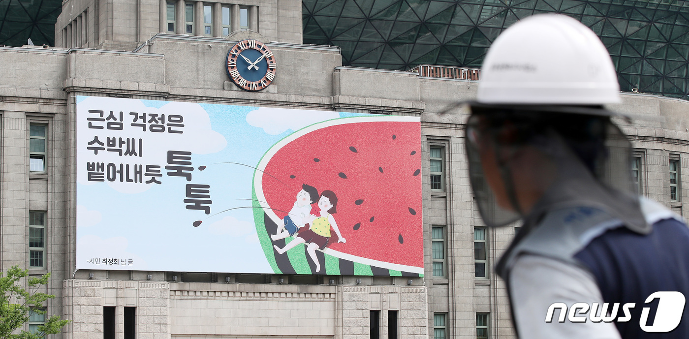 (서울=뉴스1) 박지혜 기자 = 4일 오전 여름을 맞아 무더위를 잊게 해주는 시원하고 산뜻한 새문구로 단장한 서울시청 앞 서울도서관 외벽 꿈새김판 앞으로 시민들이 지나가고 있다.서 …