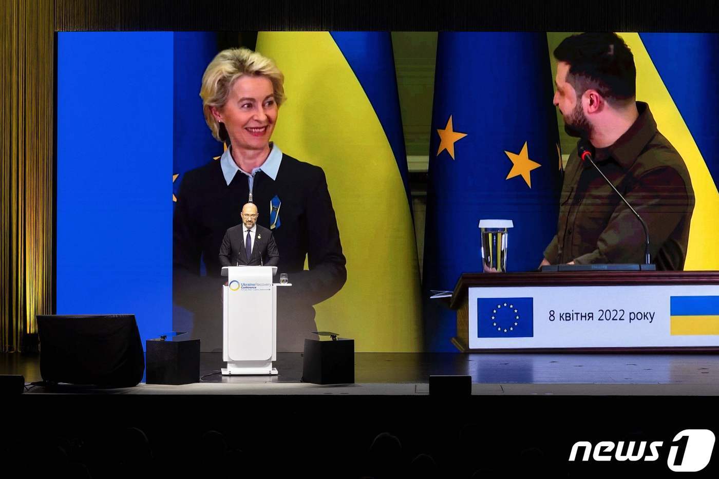 본문 이미지 - 데니스 슈미갈 우크라이나 총리가 4일(현지시간) 스위스 루가노에서 열린 '우크라이나 재건회의'에서 볼로디미르 젤렌스키 우크라이나 대통령과 우르줄라 폰데어라이엔 EU 집행위원장의 모습이 비치는 화면을 배경으로 연설하고 있다. ⓒ AFP=뉴스1 ⓒ News1 우동명 기자