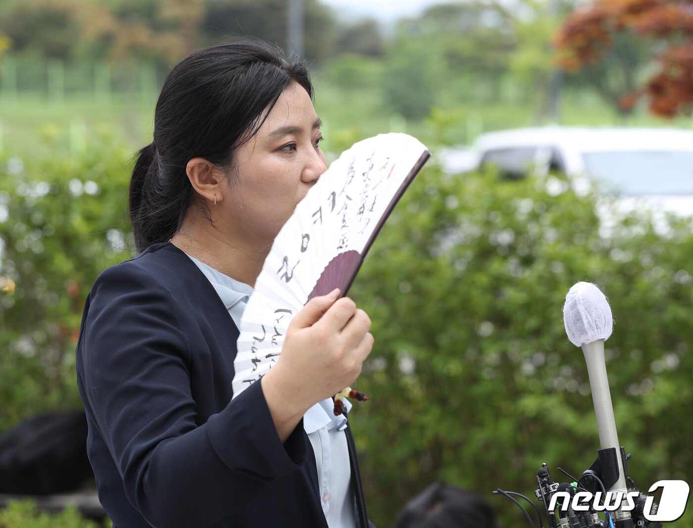 본문 이미지 - 김성진 아이카이스트 대표의 법률 대리인인 김소연 변호사가 5일 오후 경기 의왕시 서울구치소 앞에서 취재진을 향해 부채를 들어보이고 있다. 2022.7.5/뉴스1 ⓒ News1 신웅수 기자