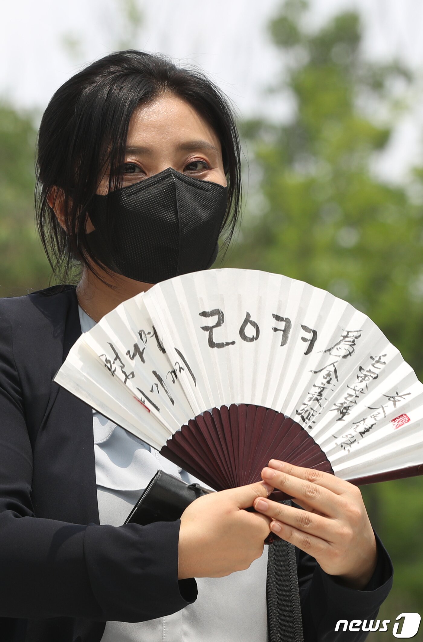 본문 이미지 - 김성진 아이카이스트 대표의 법률 대리인인 김소연 변호사가 5일 오후 경기 의왕시 서울구치소 앞에서 취재진을 향해 부채를 들어보이고 있다. 2022.7.5/뉴스1 ⓒ News1 신웅수 기자