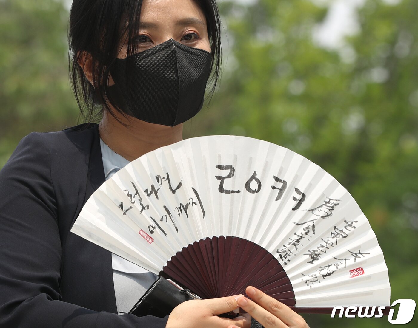 본문 이미지 - 김성진 아이카이스트 대표의 법률 대리인인 김소연 변호사가 5일 오후 경기 의왕시 서울구치소 앞에서 취재진을 향해 부채를 들어보이고 있다.  2022.7.5/뉴스1 ⓒ News1 신웅수 기자