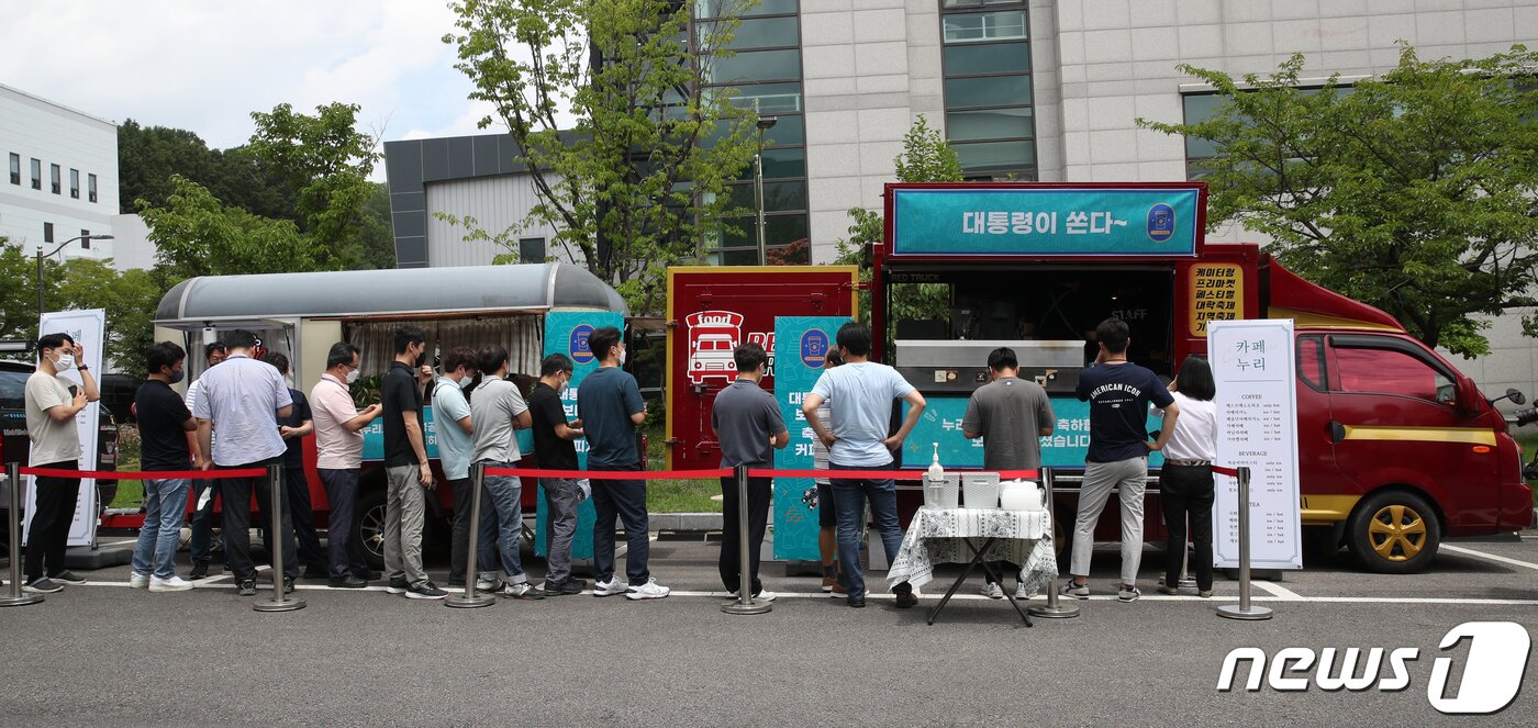 본문 이미지 - 한국항공우주연구원 직원들이 6일 대전 유성구 항우연에서 음료를 주문하기 위해 줄 서 있다. 윤석열 대통령은 이날 누리호 2차 발사 성공 등을 위해 노력한 연구원들을 위해 커피와 쿠키 푸드트럭을 보냈다. 대통령실사진기자단 2022.7.6/뉴스1 ⓒ News1 안은나 기자
