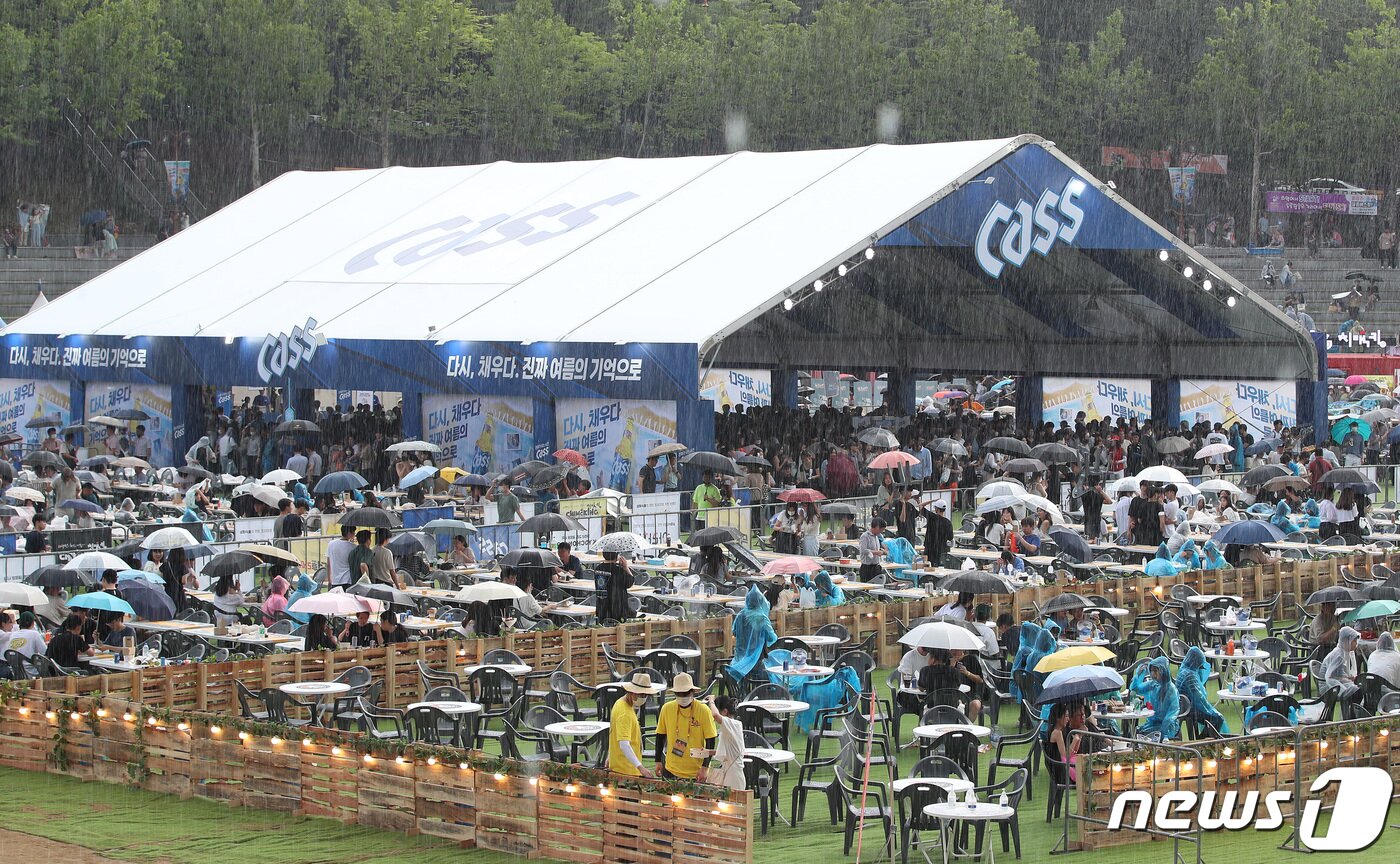 본문 이미지 - 6일 오후 대구 달서구 두류야구장에서 열린 '2022 대구치맥페스티벌'을 찾은 시민들이 갑자기 쏟아지는 소낙비에도 자리를 지키고 있다. 2022.7.6/뉴스1 ⓒ News1 공정식 기자