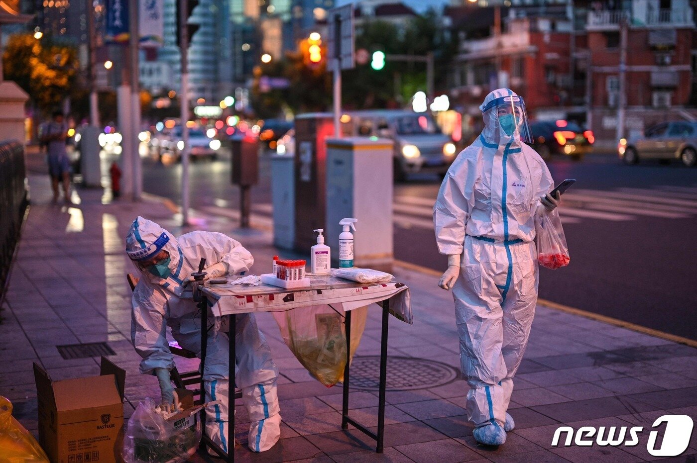 본문 이미지 - 중국 상하이 징안구의 한 주거 지역에서 방역 담당자들이 코로나19 진단검사를 준비하고 있다. ⓒ AFP=뉴스1 ⓒ News1 강민경 기자