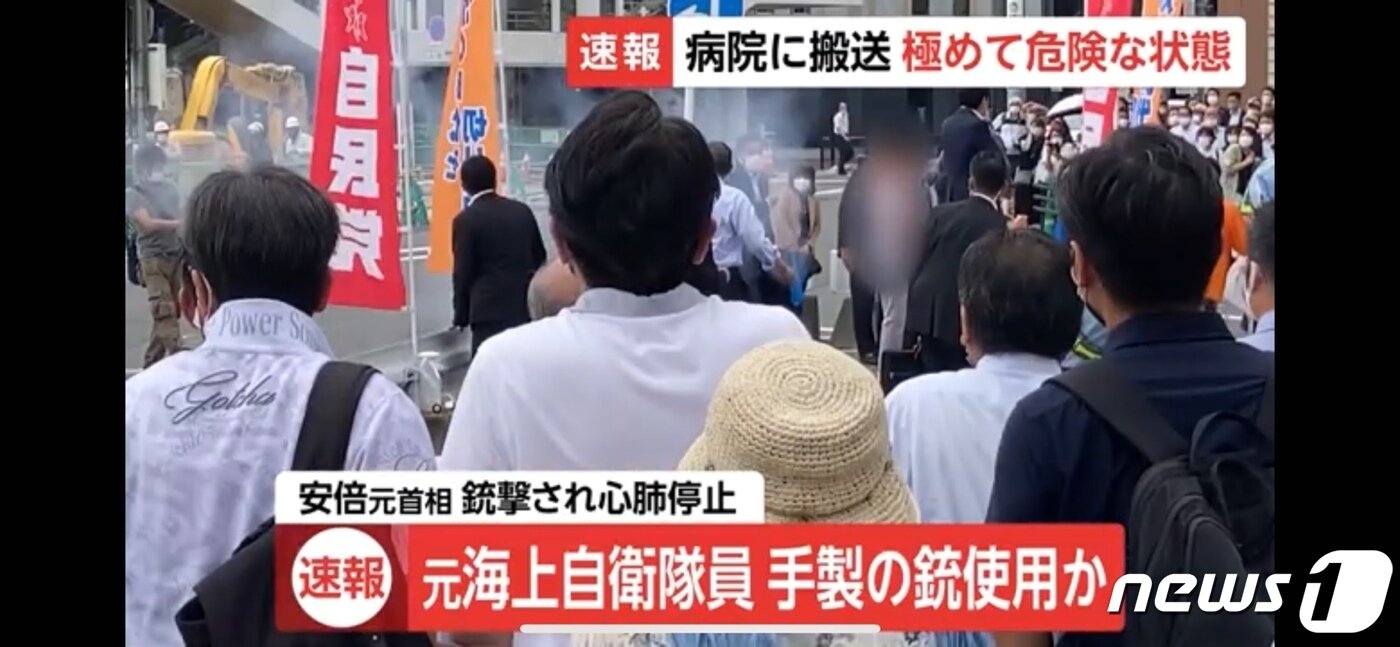 본문 이미지 - 아베 신조 전 일본 총리를 향해 한 남성이 총을 쏜 직후 모습.  남성은 맨 왼쪽, 연기가 시작되는 쪽에 있다. ⓒ 뉴스1 (FNN 뉴스 캡쳐 갈음)