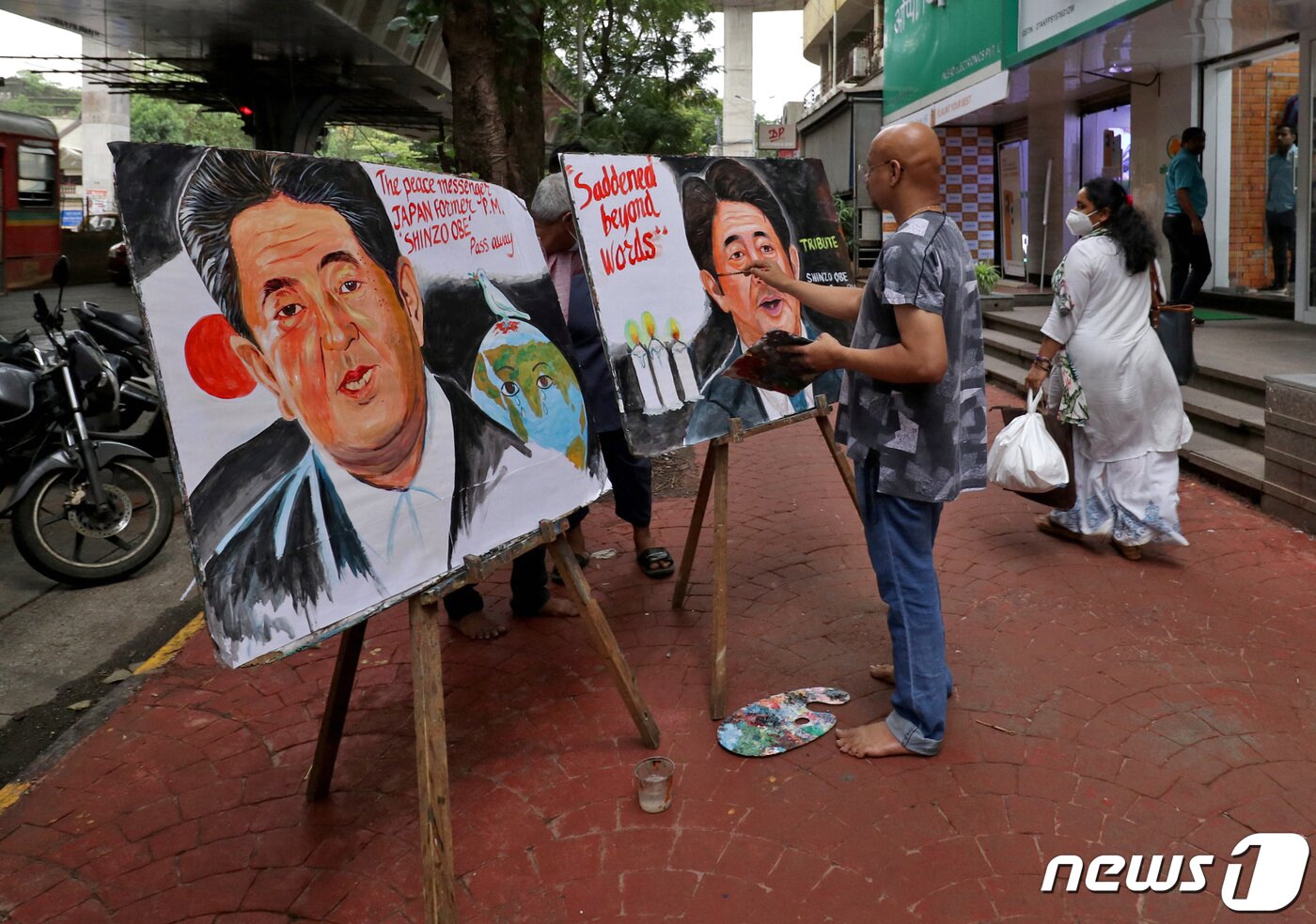 본문 이미지 - 아베 신조 전 일본 총리가 선거 유세중 총에 맞고 숨진 다음날인 8일(현지시간) 인도 뭄바이에서 예술가들이 아베 총리의 모습을 그리고 있다. ⓒ 로이터=뉴스1 ⓒ News1 이성철 기자
