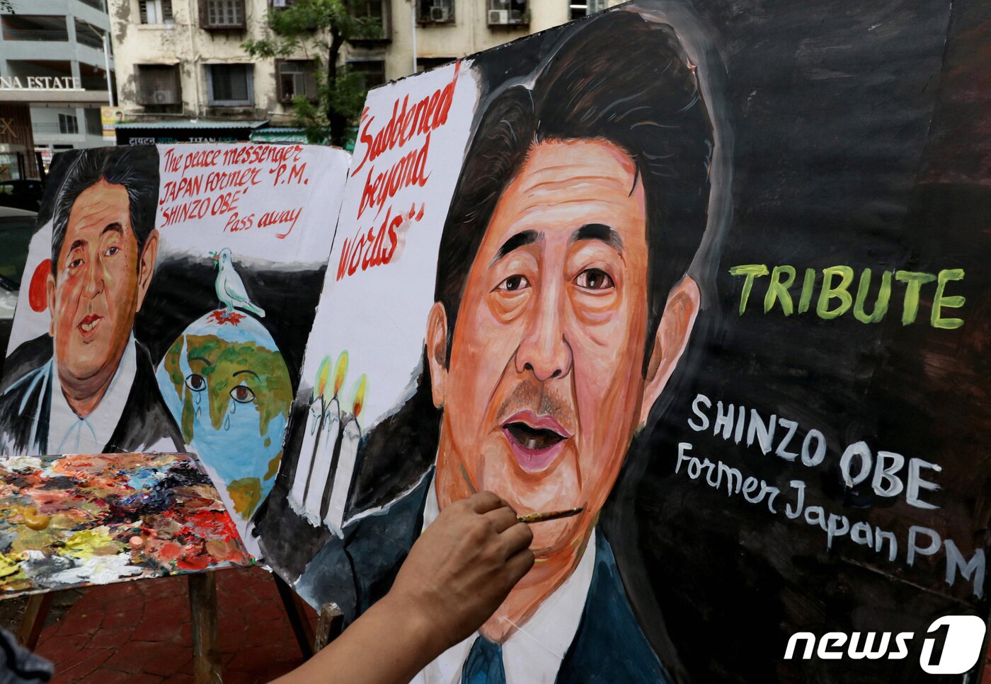 본문 이미지 - 아베 신조 전 일본 총리가 선거 유세중 총에 맞고 숨진 다음날인 8일(현지시간) 인도 뭄바이에서 예술가들이 아베 총리의 모습을 그리고 있다. ⓒ 로이터=뉴스1 ⓒ News1 이성철 기자