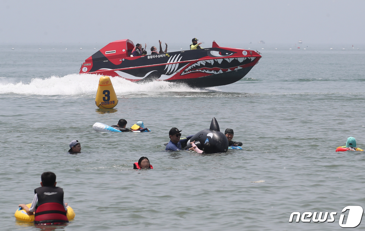 (인천=뉴스1) 송원영 기자 = 폭염이 기승을 부린 9일 인천 중구 을왕리해수욕장을 찾은 시민들이 물놀이를 하며 더위를 식히고 있다. 2022.7.9/뉴스1