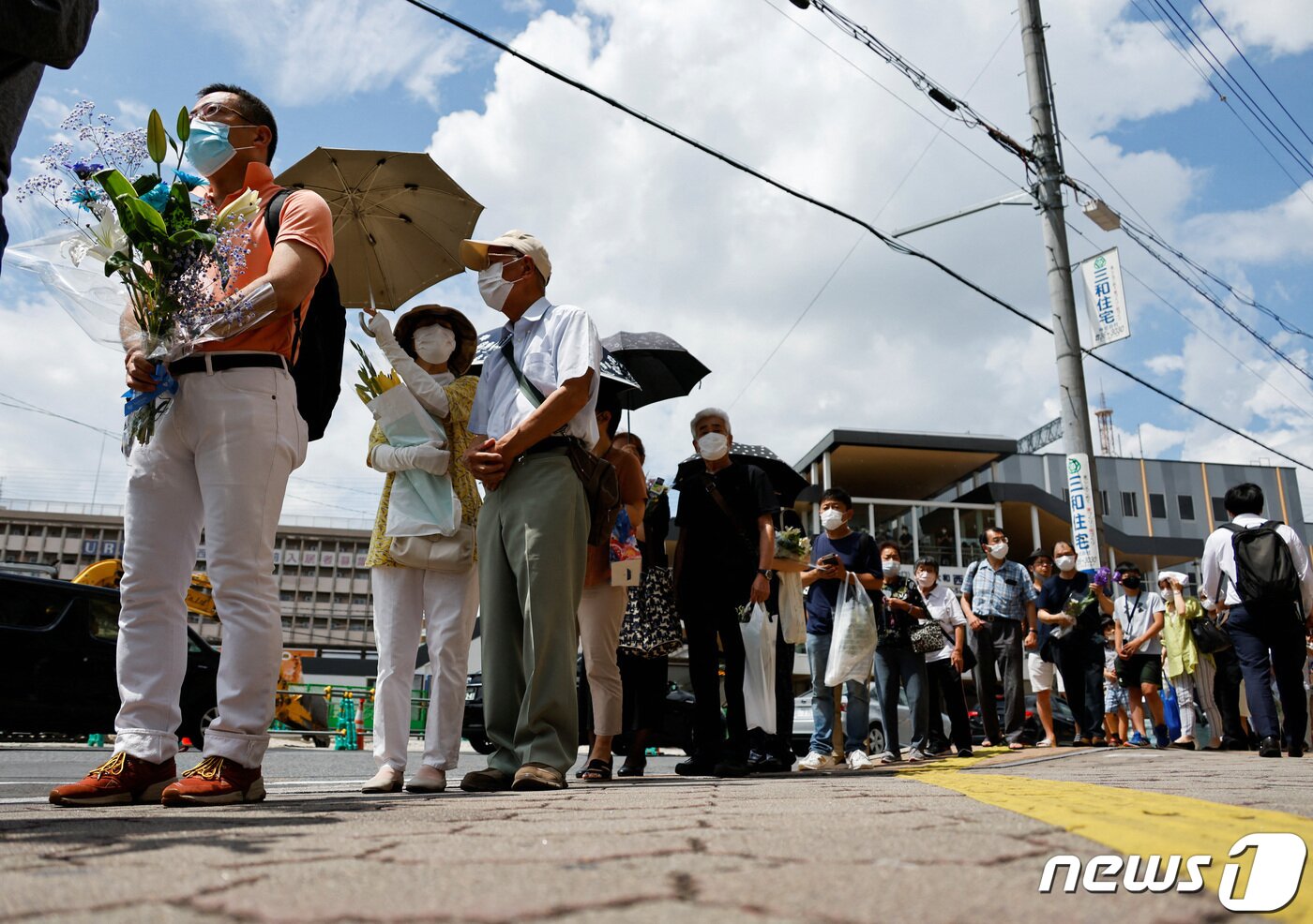 본문 이미지 - 아베 신조 전 일본 총리가 선거 유세중 총에 맞고 숨진 다음날인 9일(현지시간) 일본 나라시에서 시민들이 아베 전 총리가 피격당한 현장에 헌화를 위해 줄을 서고 있다. 2022.07.09 ⓒ 로이터=뉴스1 ⓒ News1 이성철 기자