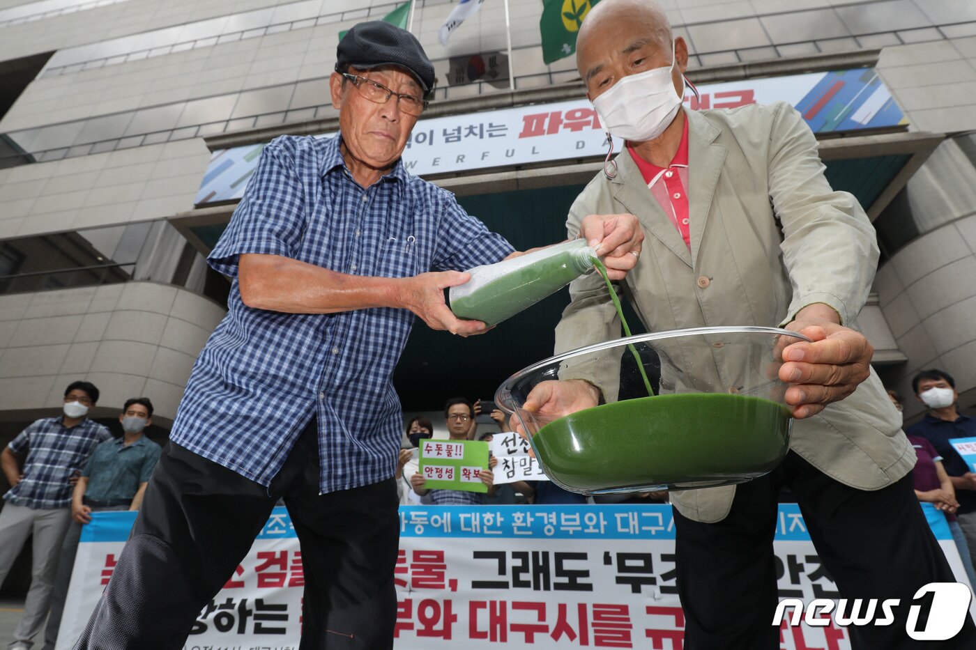 본문 이미지 - 낙동강네트워크·낙동강대구경북네트워크 등 영남권 환경단체 회원들이 1일 오전 대구시청 동인청사 앞에서 대구 수돗물 녹조 독소 오염 파동에 대한 환경부와 대구시의 대책 마련을 촉구하는 기자회견을 열고 달성군 매곡정수장 인근 낙동강에서 퍼온 물을 투명 용기에 따르고 있다. 2022.8.1/뉴스1 ⓒ News1 공정식 기자