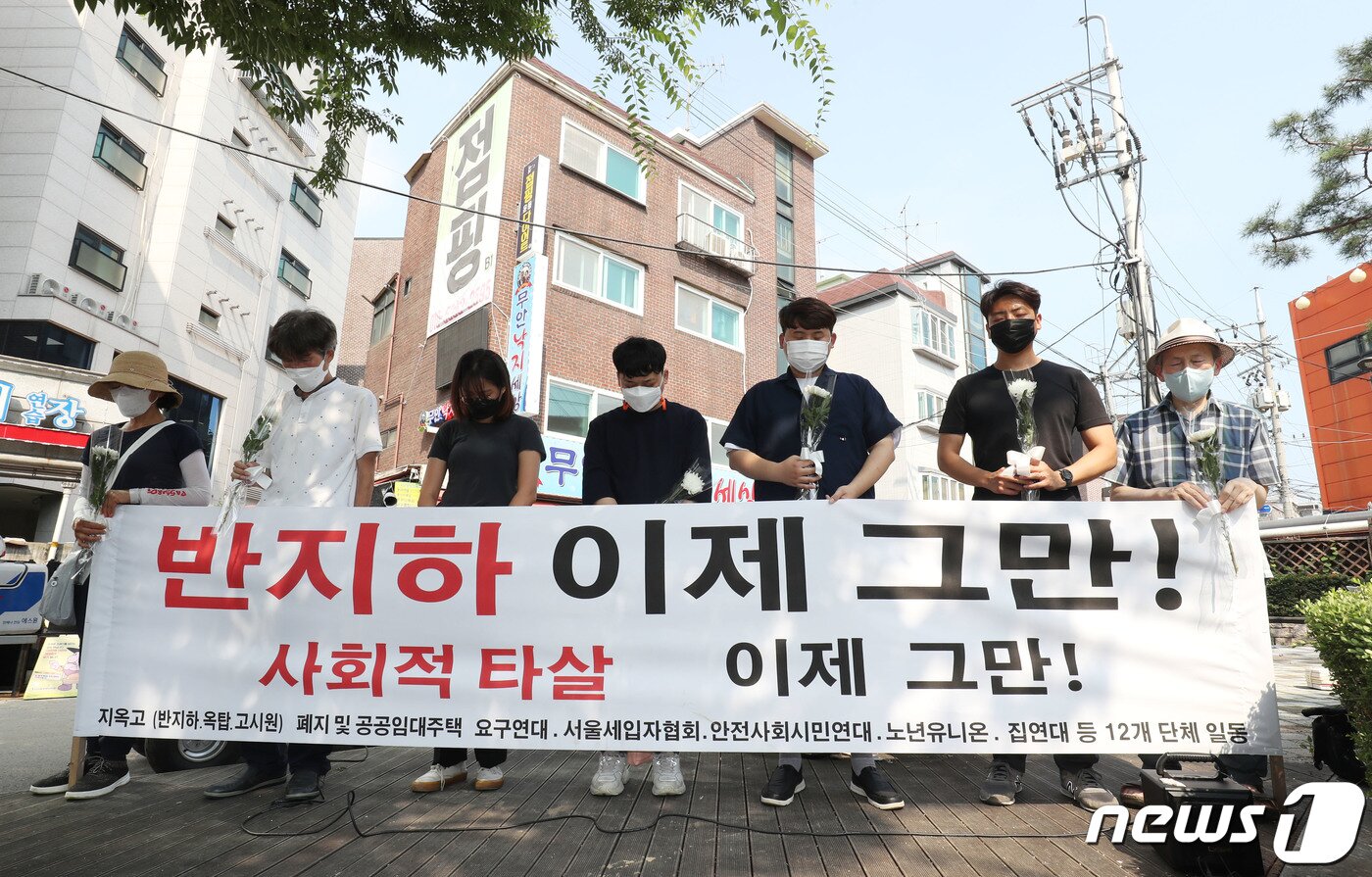 본문 이미지 - 정부에 반지하 대책을 요구하는 시민단체가 피해자들을 추모하며 묵념을 하고 있다. 2022.8.12/뉴스1 ⓒ News1 이성철 기자