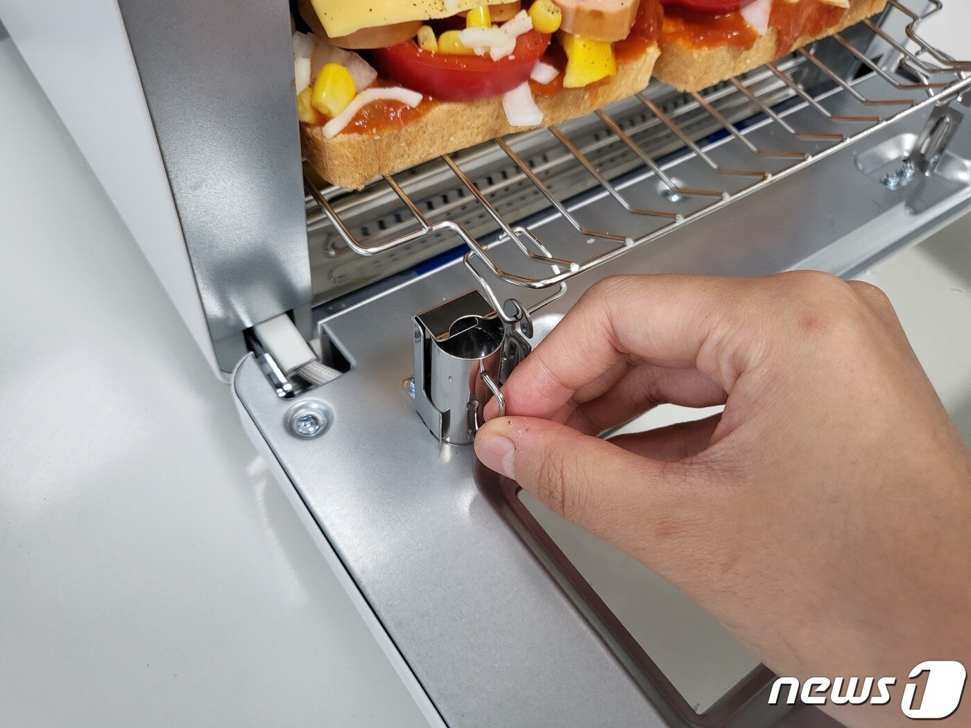 본문 이미지 - 취재진이 쿠쿠 스팀 토스터기에 스테인리스 컵을 장착하는 모습. ⓒ 뉴스1