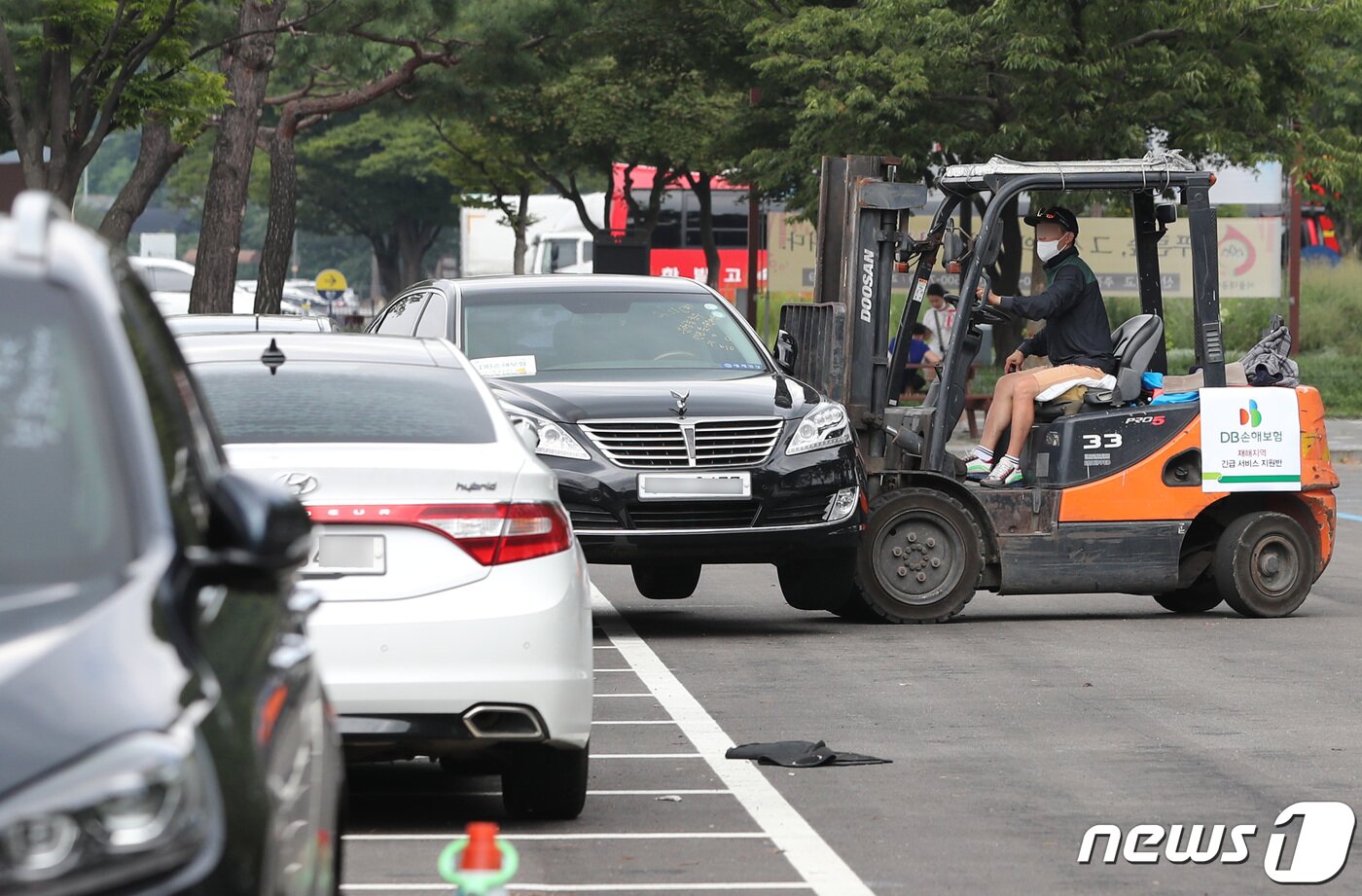 본문 이미지 - 14일 오후 경기 과천시 서울대공원 주차장에 마련된 보험사 침수차량 집결 장소에서 보험사 직원이 침수차를 옮기고 있다.  2022.8.14/뉴스1 ⓒ News1 구윤성 기자