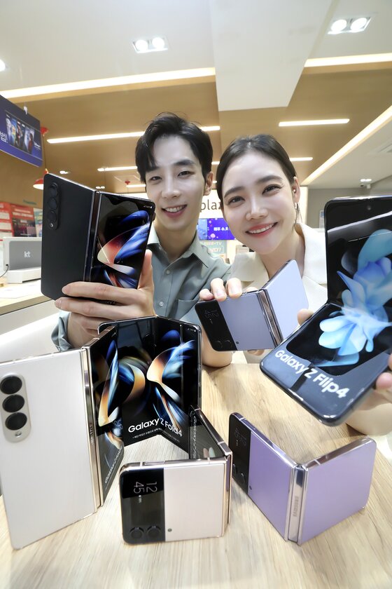 본문 이미지 - KT가 16일부터 22일까지 7일간 전국 KT 매장 및 공식 온라인몰 KT Shop에서 삼성전자 ‘갤럭시 Z폴드·플립4’ 시리즈 사전예약을 진행한다고 15일 밝혔다. 사전예약 개통은 23일부터이며 공식 출시는 26일이다. 사진은 모델들이 삼성전자 폴더블폰 ‘갤럭시 Z 폴드4’와 ‘갤럭시 Z 플립4’ 사전예약을 소개하고 있는 모습. (KT 제공) 2022.8.15/뉴스1