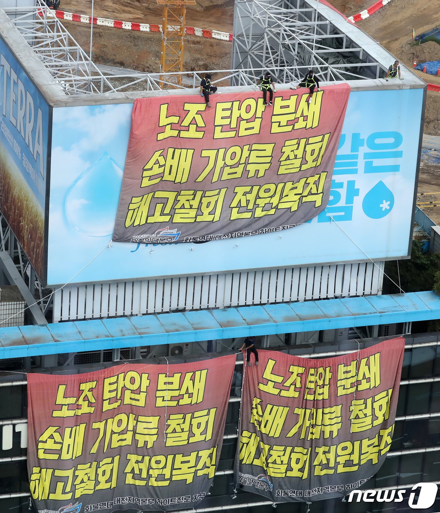 하이트진로 본사 옥상에서 고공농성 중인 화물연대 조합원들이 18일 지상에서 열린 결의대회를 지켜보고 있다. 2022.8.18/뉴스1 ⓒ News1 김진환 기자