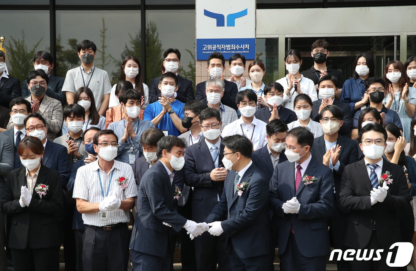 본문 이미지 - 김진욱 고위공직자범죄수사처(공수처) 처장이 26일 오전 경기도 과천시 공수처 앞에서 열린 새로운 로고(CI)와 슬로건(표어)을 사용하는 현판 제막식에서 참석자들과 인사를 나누고 있다. 2022.8.26/뉴스1 ⓒ News1 임세영 기자