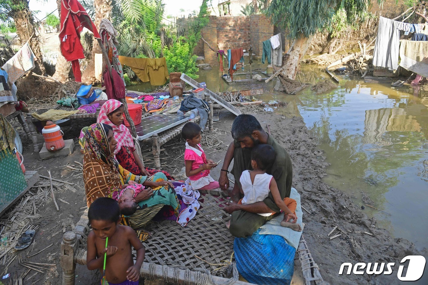 (수쿠르 AFP=뉴스1) 남해인 기자 = 28일(현지시간) 파키스탄 수쿠르에서 나히드 샤이크(사진 왼쪽)와 그의 가족들이 홍수로 폐허가 된 집 주변에 앉아있다. 파키스탄재난관리청이 …