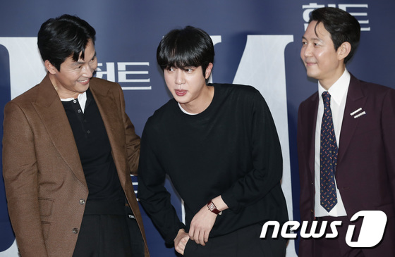 방탄소년단(BTS) 진(가운데)이 2일 오후 서울 강남구 메가박스 코엑스점에서 열린 영화 '헌트(HUNT)' VIP 시사회에서 주머니에서 뭔가를 꺼내고 있다.  © News1 권현진 기자