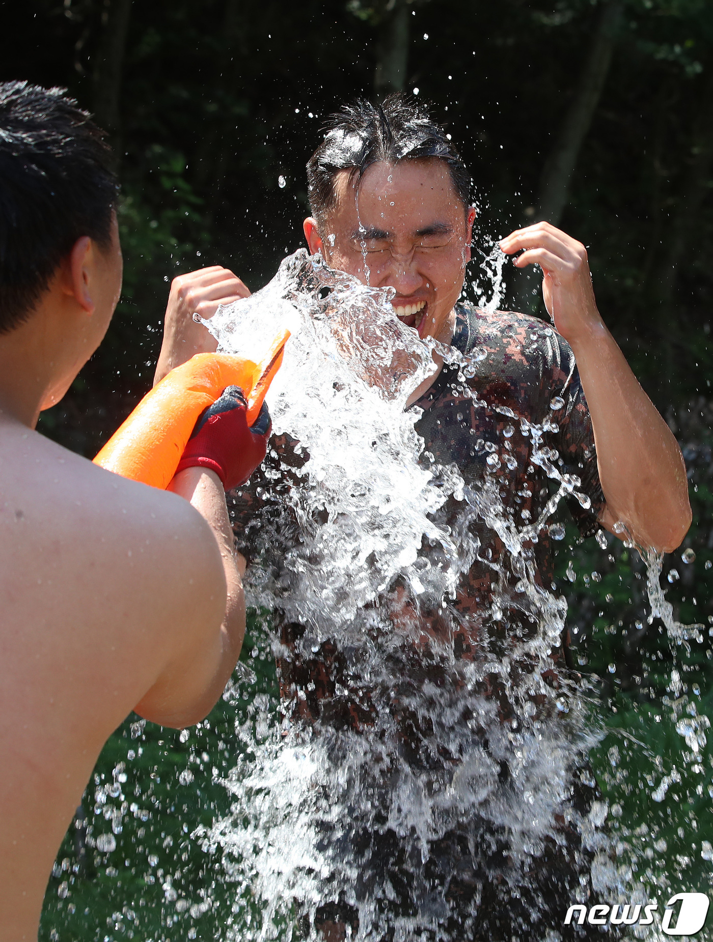 (대구=뉴스1) 공정식 기자 = 육군 50사단 낙동강여단 장병들이 3일 오전 대구 달성군 가창유격장에서 열린 유격훈련과 참호격투를 마친 뒤 냉수로 샤워를 하며 무더위를 씻어내고 있 …