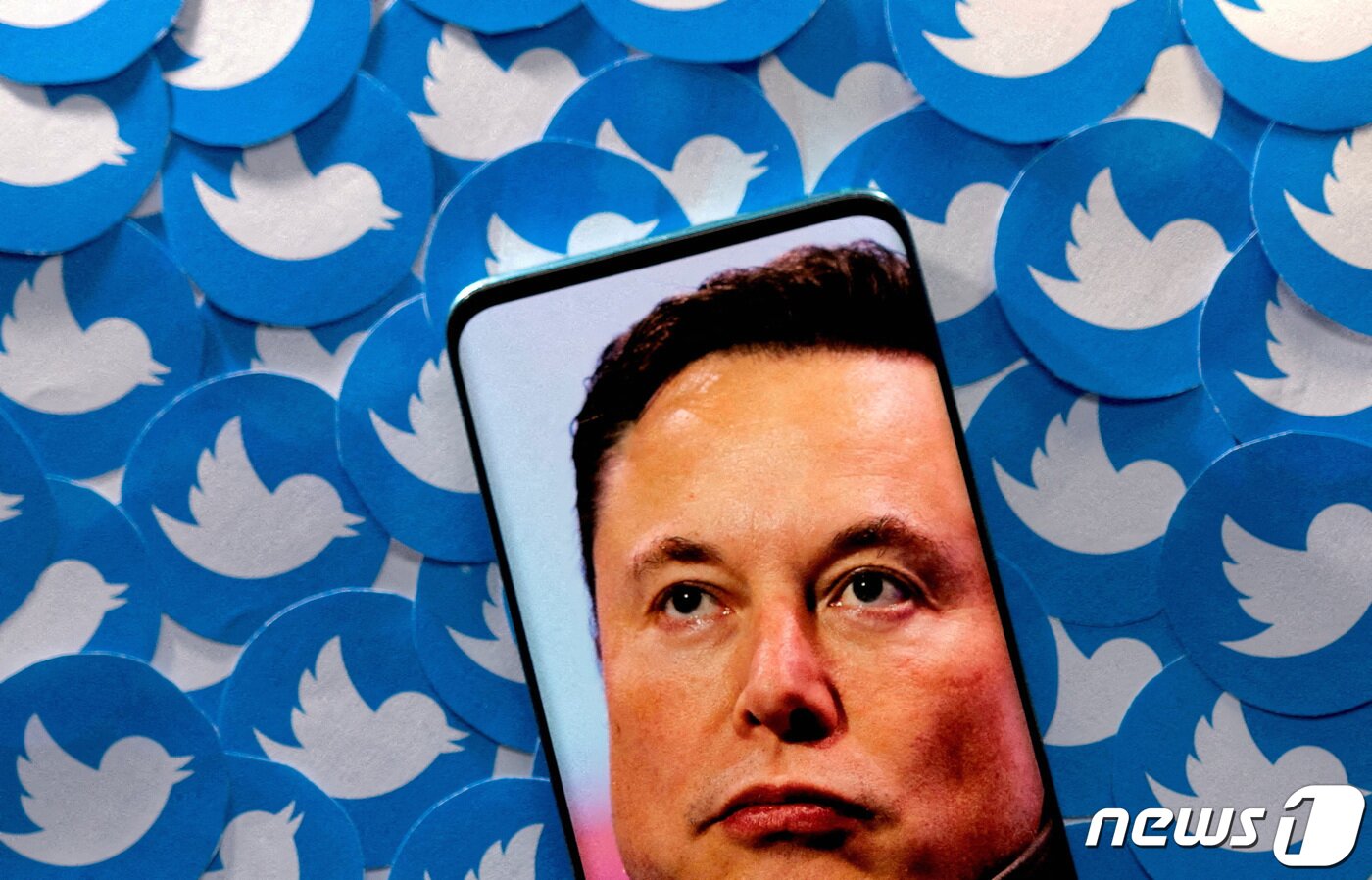 본문 이미지 - 일론 머스크 사진과 인쇄된 트위터 로고들이 나온 일러스트. 2022.04.28. ⓒ 로이터=뉴스1 ⓒ News1 박기현 기자