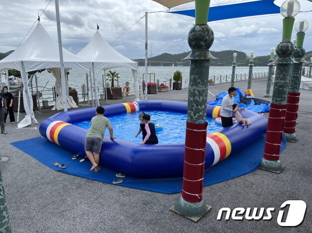 본문 이미지 - 마량놀토수산시장에 설치된 간이수영장. 싱싱한 회도 맛보고 공연도 보고 물놀이도 즐기는 1석3조 효과를 누릴 수 있다.ⓒ 뉴스1