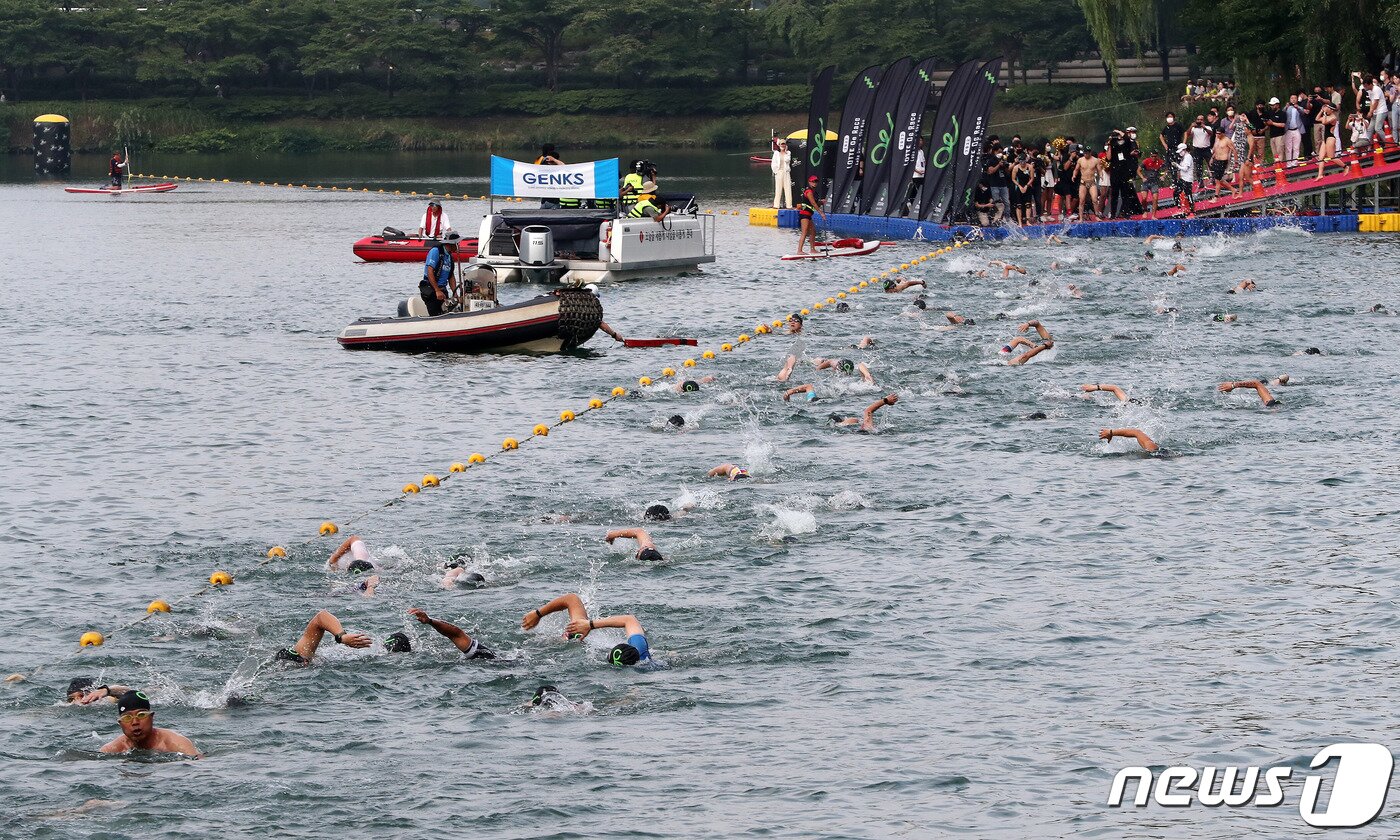 본문 이미지 - 7일 오전 서울 송파구 석촌호수와 롯데월드타워에서 열린 '2022 LOTTE Oe Race'에서 참가자들이 수영을 하고 있다. 2022.8.7/뉴스1 ⓒ News1 박세연 기자