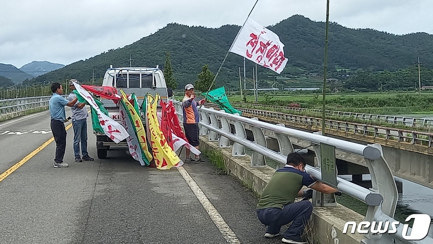 본문 이미지 - 지력산 레이더 기지 저지대책위 주민들이 도로위 다리에 레이더부대 반대 현수막을 설치하고 있다. ⓒ News1 