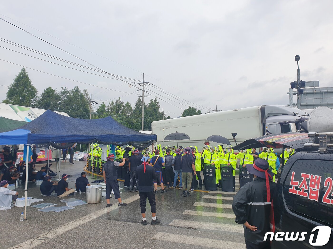 본문 이미지 - 8일 오전 강원도 홍천 하이트진로 강원공장에서 맥주를 실은 물류차량들이 경찰이 확보한 진출입로를 통해 인근 물류센터로 이동하고 있다. 2022.8.8/뉴스1 ⓒ News1 이종재 기자