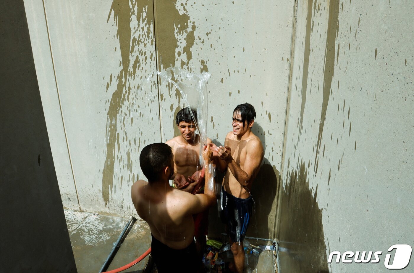 본문 이미지 - 7일(현지시간) 이라크 바그다드에서 모크타다 알사드르 지지자들이 시위 참여 중 더위를 식히고 있다. 2022. 8. 7. ⓒ 로이터=뉴스1 ⓒ News1 최서윤 기자