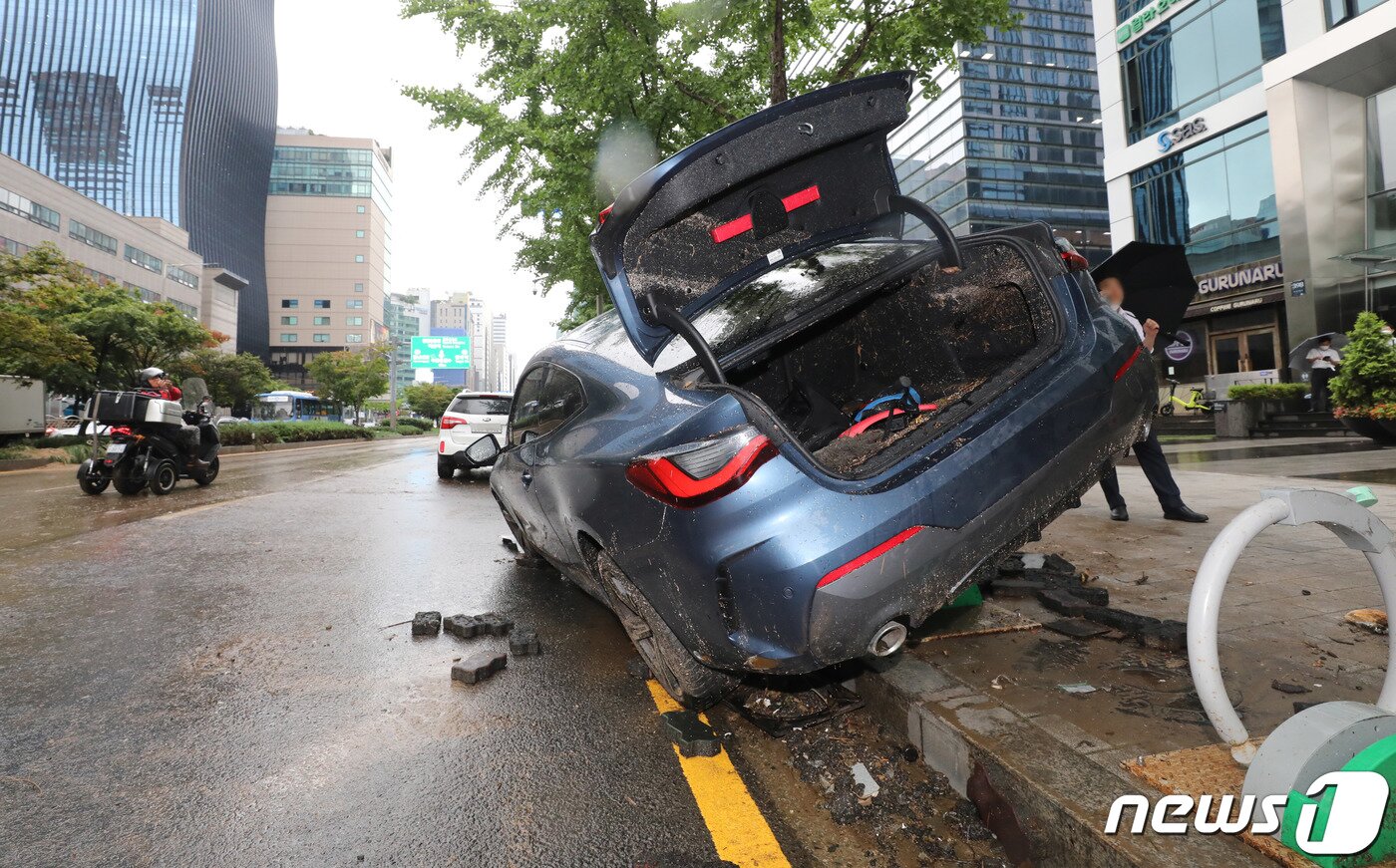 본문 이미지 - 서울을 비롯한 중부지역에 기록적인 폭우가 내린 9일 오전 서울 서초구 서초동 진흥아파트 앞 서초대로에 전날 쏟아진 폭우에 침수, 고립된 차량이 인도위 자전거거치대에 올라서 있다. 2022.8.9/뉴스1 ⓒ News1 박세연 기자
