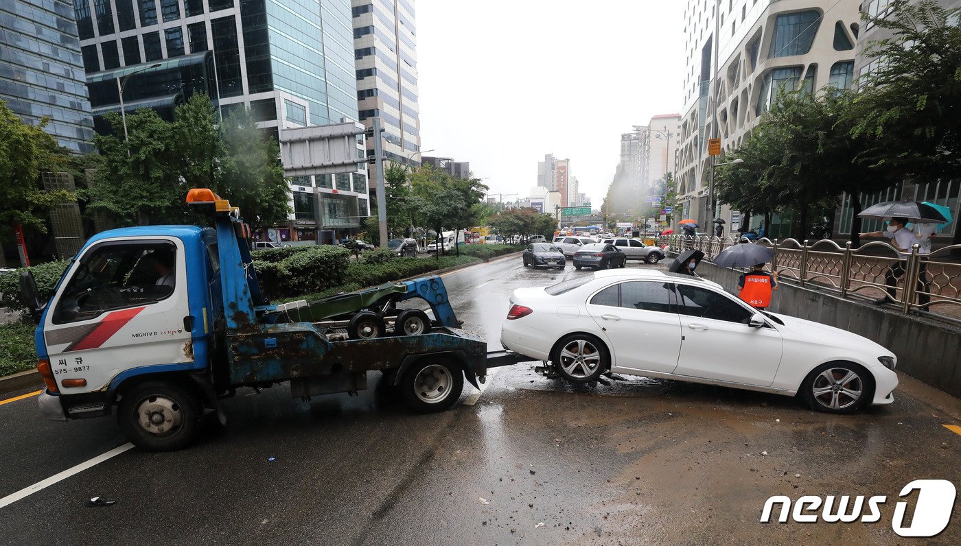 본문 이미지 - 서울을 비롯한 중부지역에 기록적인 폭우가 내린 9일 서울 서초구 서초동 진흥아파트 앞 서초대로에 폭우에 침수, 고립된 차량이 견인되고 있다. 2022.8.9/뉴스1 ⓒ News1 박세연 기자