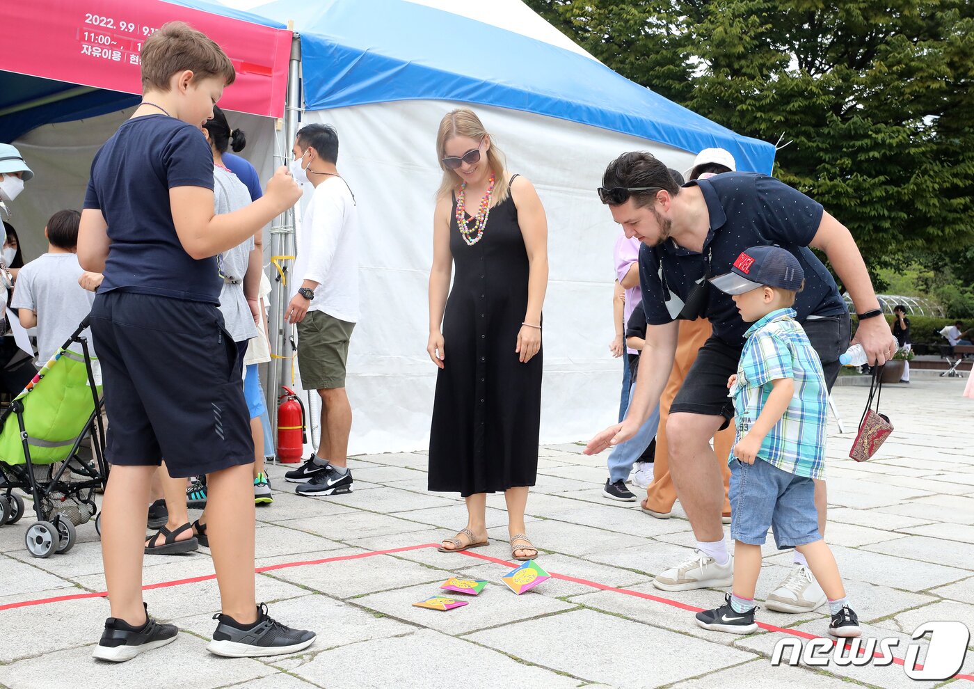 본문 이미지 - 오전 서울 종로구 국립민속박물관에서 열린 &#39;한가위, 보름달 걸렸네&#39;에서 외국인 관광객들이 딱지치기를 하고 있다. 2022.9.11/뉴스1 ⓒ News1 김진환 기자