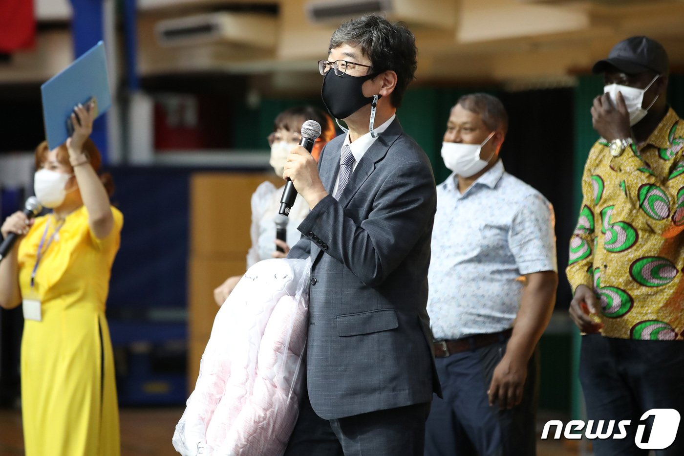 본문 이미지 -  고경수 목사가 11일 오후 대구 달서구 신당동 계명문화대학교 체육관에서 열린 '2022년 이주민과 함께하는 추석 축제'에서 환영 인사를 하고 있다. 고 목사가 들고 있는 이불은 이날 축제 참석자 가운데 가장 나이가 많은 이주민에게 선물했다. 2022.9.12/뉴스1 ⓒ News1 공정식 기자