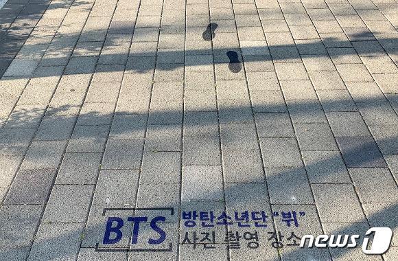 본문 이미지 - BTS 멤버 뷔가 다녀간 부산시민공원 바닥에 사진촬영 장소가 표시돼 있다.(비짓부산 갈무리) 