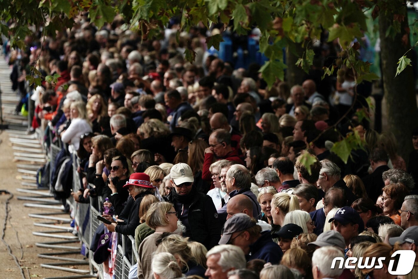 본문 이미지 - 엘리자베스 2세 여왕의 영구가 영국 런던 버킹엄궁에서 웨스트민스터 사원으로 운구되는 14일(현지시간) 버킹험 궁 앞 직선 구간인 더 몰에 시민들이 모여있다. ⓒ 로이터=뉴스1