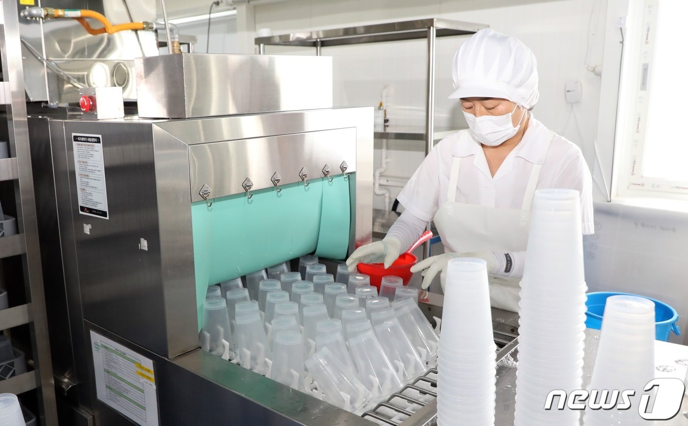 본문 이미지 -  다회용컵을 고압물줄기로 2차 세척하는 모습.